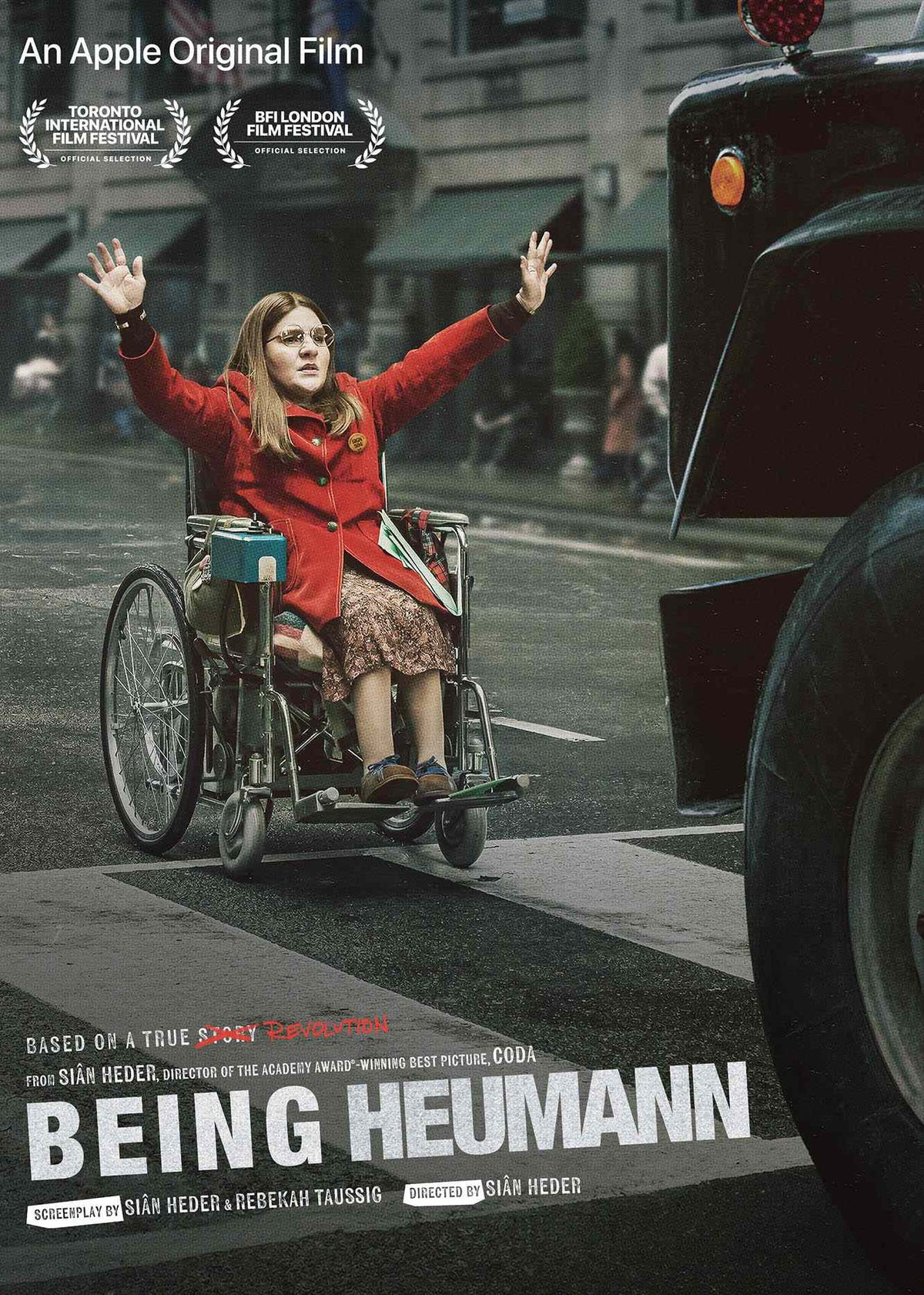 Movie poster for 'Being Heumann.' Ruth Madeley as disability rights activist Judy Heumann sits in her wheelchair in the middle of a busy city street, raising both hands defiantly in protest as a large car approaches