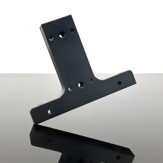 A black SlingShot adaptor tilted at an angle over a reflective surface against a white background