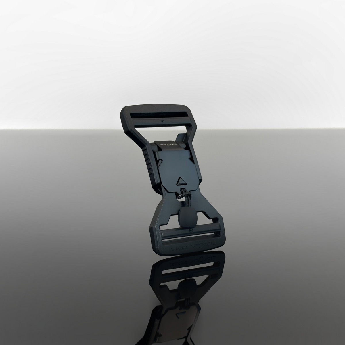 A black magnetic quick release fidlock buckle stood up against a grey and white background