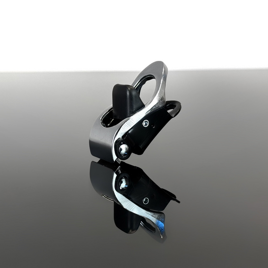 A silver harness ratchet displayed on a reflective dark surface against a white background.