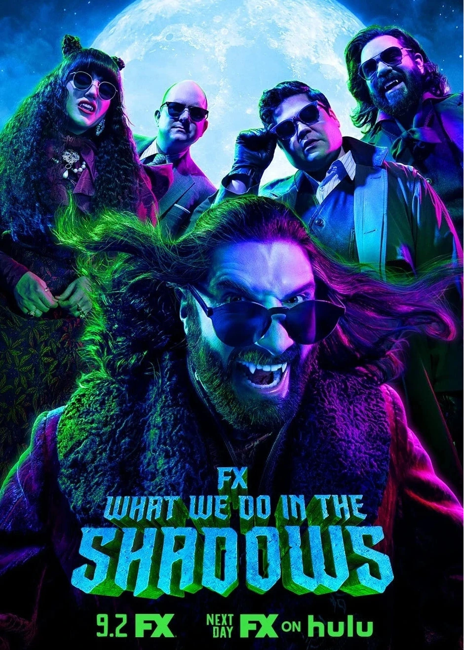 Promotional poster for FX's 'What We Do in the Shadows' season 3 featuring the cast in stylized neon lighting against a large moon background.